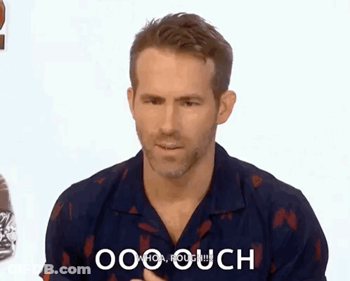 A Man In A Blue Shirt Is Making A Funny Face While Talking To Someone . GIF