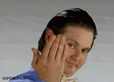 A Man In A Blue Shirt Is Making A Funny Face With His Hands GIF