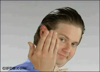 A Man In A Blue Shirt Is Making A Funny Face With His Hands . GIF