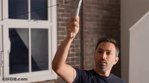 A Man In A Blue Shirt Is Measuring Something GIF