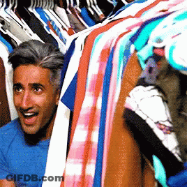 A Man In A Blue Shirt Is Peeking Out Of A Closet GIF