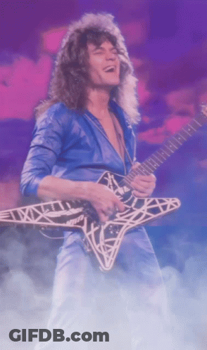 A Man In A Blue Shirt Is Playing A Guitar With A Star Design On It GIF