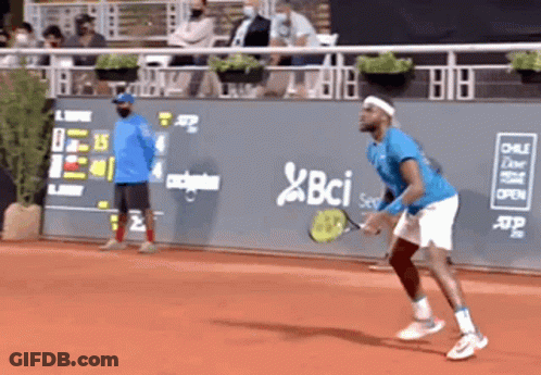 A Man In A Blue Shirt Is Playing Tennis On A Court With A Bci Logo On The Wall Behind Him GIF