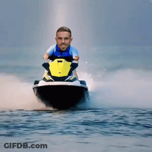 A Man In A Blue Shirt Is Riding A Jet Ski GIF