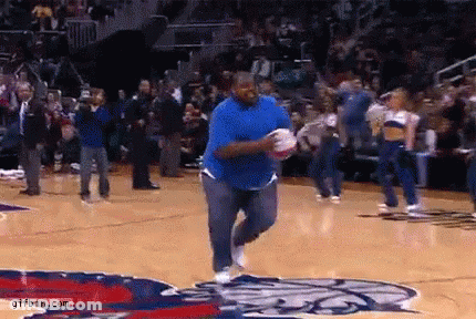 A Man In A Blue Shirt Is Running On A Basketball Court Holding A Basketball . GIF