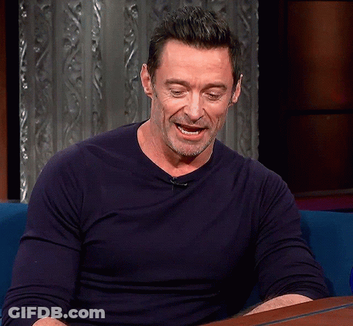A Man In A Blue Shirt Is Sitting At A Table GIF