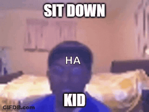 A Man In A Blue Shirt Is Sitting Down In A Bedroom . GIF