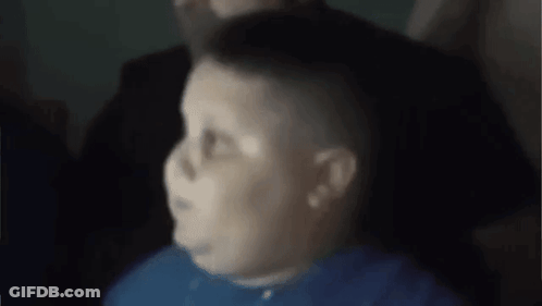 A Man In A Blue Shirt Is Sitting In A Chair With His Eyes Closed . GIF