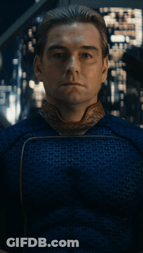 A Man In A Blue Shirt Is Sitting In Front Of A Painting With His Eyes Closed GIF