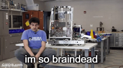 A Man In A Blue Shirt Is Sitting In Front Of A Robot That Says Im So Braindead On It GIF