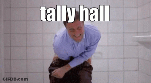 A Man In A Blue Shirt Is Sitting On A Toilet With The Words Tally Hall Above Him GIF