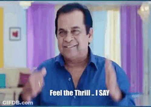 A Man In A Blue Shirt Is Smiling And Saying `` Feel The Thrill , I Say '' . GIF