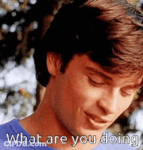 A Man In A Blue Shirt Is Smiling And Says What Are You Doing GIF