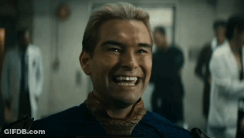 A Man In A Blue Shirt Is Smiling In A Room With Other People . GIF