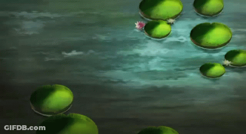 A Man In A Blue Shirt Is Standing In A Body Of Water Surrounded By Green Lily Pads GIF