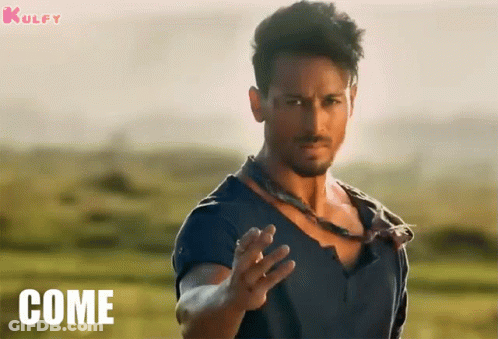A Man In A Blue Shirt Is Standing In A Field With The Word Come On The Bottom GIF