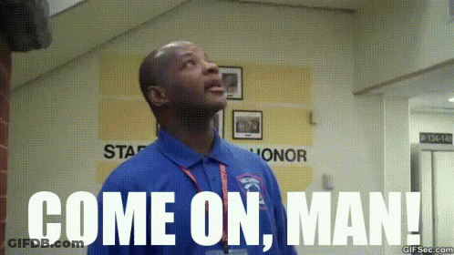 A Man In A Blue Shirt Is Standing In A Hallway And Says Come On Man . GIF