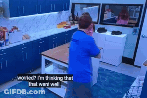 A Man In A Blue Shirt Is Standing In A Kitchen Talking To Another Man GIF