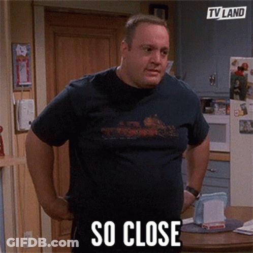 A Man In A Blue Shirt Is Standing In A Kitchen With His Hands On His Hips And Says So Close GIF