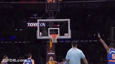 A Man In A Blue Shirt Is Standing In Front Of A Basketball Hoop With A Toyota Ad In The Background GIF