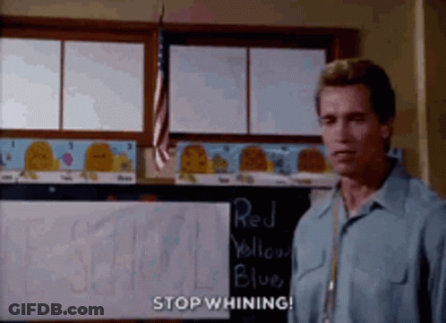A Man In A Blue Shirt Is Standing In Front Of A Blackboard That Says Stop Whining . GIF
