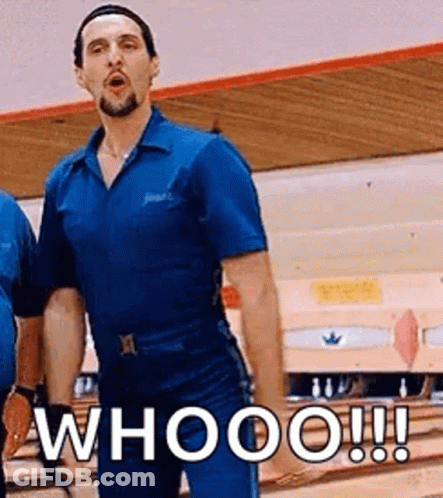 A Man In A Blue Shirt Is Standing In Front Of A Bowling Alley And Says Whooo ! GIF
