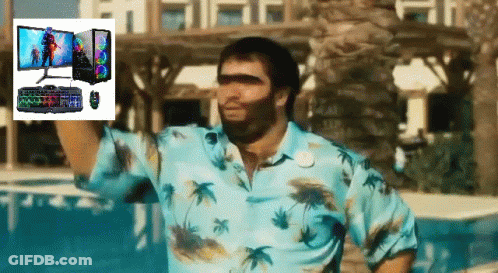 A Man In A Blue Shirt Is Standing In Front Of A Computer Monitor Keyboard And Mouse GIF