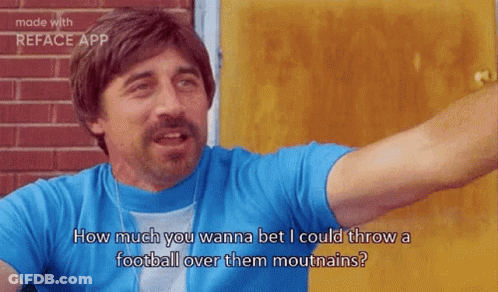 A Man In A Blue Shirt Is Standing In Front Of A Door And Talking To Someone . GIF