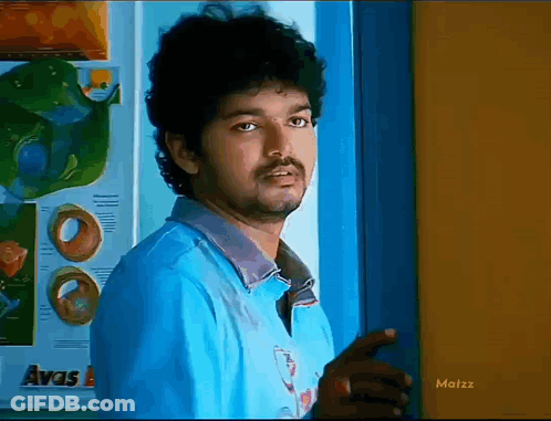 A Man In A Blue Shirt Is Standing In Front Of A Door With The Word Avas On It GIF