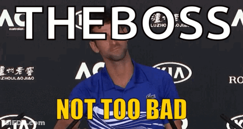 A Man In A Blue Shirt Is Standing In Front Of A Sign That Says " At The Boss " GIF