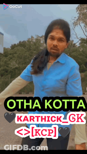 A Man In A Blue Shirt Is Standing In Front Of A Sign That Says Otha Kotta Karthick Gk Kcp GIF