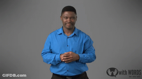 A Man In A Blue Shirt Is Standing In Front Of A Sign That Says " With Words " GIF