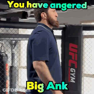 A Man In A Blue Shirt Is Standing In Front Of A Ufc Gym GIF