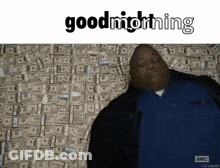 A Man In A Blue Shirt Is Standing In Front Of A Wall Of Money And Says Goodnight GIF