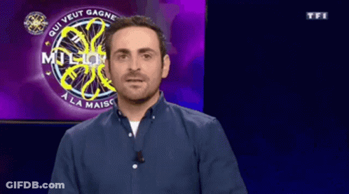 A Man In A Blue Shirt Is Standing In Front Of A Who Wants To Be A Millionaire Sign GIF