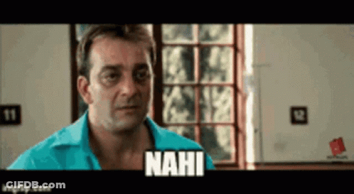 A Man In A Blue Shirt Is Standing In Front Of A Window And Says Nahi GIF