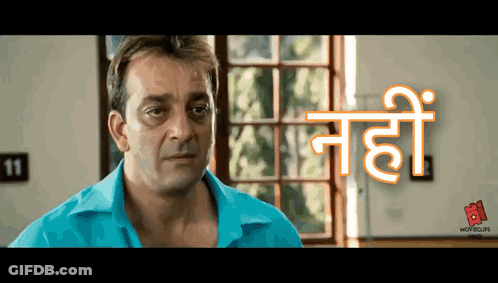 A Man In A Blue Shirt Is Standing In Front Of A Window With The Number 11 On The Wall Behind Him GIF
