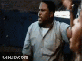 A Man In A Blue Shirt Is Standing In Front Of A Woman . GIF
