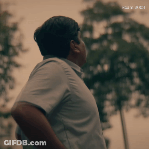 A Man In A Blue Shirt Is Standing In Front Of Trees And The Year 2003 Is On The Bottom GIF