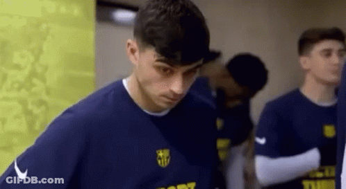 A Man In A Blue Shirt Is Standing Next To A Group Of Soccer Players . GIF
