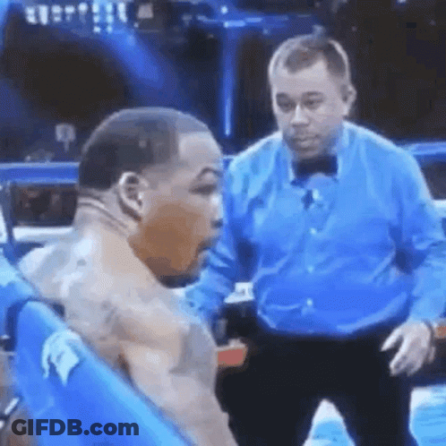 A Man In A Blue Shirt Is Standing Next To A Man In A Boxing Ring . GIF