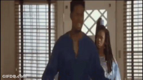 A Man In A Blue Shirt Is Standing Next To A Woman In A Blue Dress GIF