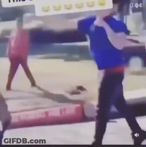 A Man In A Blue Shirt Is Standing Next To A Woman In A Red Shirt In A Blurry Photo . GIF