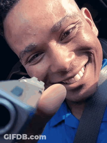 A Man In A Blue Shirt Is Taking A Selfie With A Camera GIF