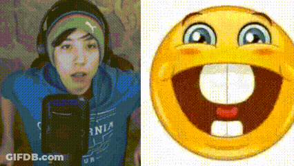 A Man In A Blue Shirt Is Talking Into A Microphone Next To A Smiley Face With A Big Mouth And Teeth . GIF