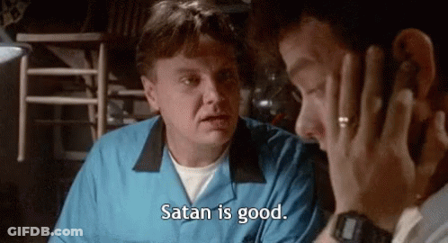 A Man In A Blue Shirt Is Talking On A Cell Phone To Another Man . GIF
