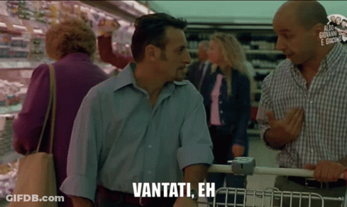 A Man In A Blue Shirt Is Talking To Another Man In A Grocery Store And Says Vantati Eh GIF