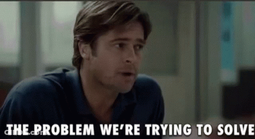 A Man In A Blue Shirt Is Talking To Another Man In A Room . GIF