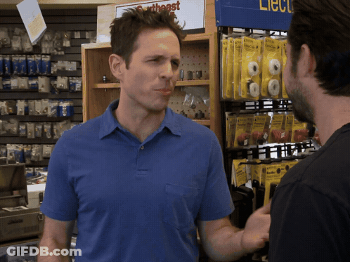 A Man In A Blue Shirt Is Talking To Another Man In Front Of A Sign That Says ' Southeast ' GIF