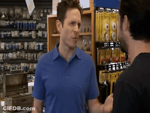 A Man In A Blue Shirt Is Talking To Another Man GIF